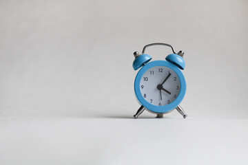 Blue, vintage clock on white textured background