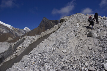 Hikers crossing Ngozumpa glacier (longest Himalayan glacier). Stone covered glacier.