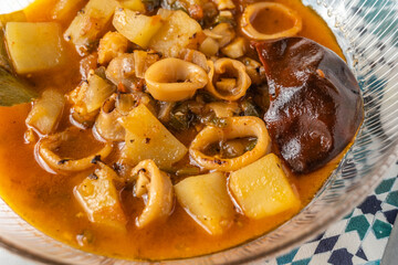 Squid stewed with potatoes blue tablecloth drawings. close up