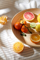 food, healthy eating and vegetarian concept - close up of citrus fruits on wooden plate