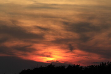 sunset in the clouds with the sun north of Hutchinson Kansas USA out in the country.
