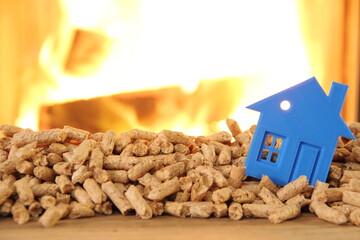 a wood stove with pellets, wood and a toy house
