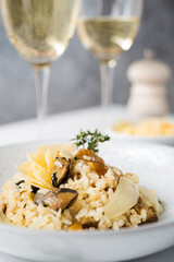Risotto with porcini mushrooms and parmesan on a light background, selective focus