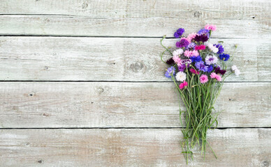Colorful bouquet of summer garden flowers. Cornflowers on old shabby wooden table. Vintage floral background. Copy space
