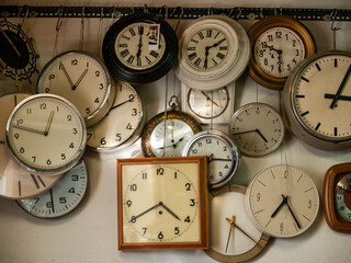 collection of vintage clocks hanging on a wall