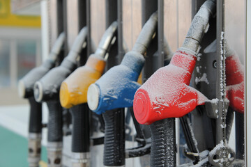 Refueling nozzles at a gas station covered with snow. The crisis. Economic crisis. Refueling the car in winter.