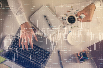 Multi exposure of man's hands typing over computer keyboard and forex graph hologram drawing. Top view. Financial markets concept.