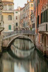 Old bridge in Venice Italy over a canal and surrounded by old buildings. 