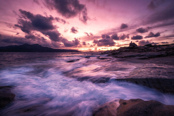 Sunset over tower and rocky coastline of Corsica