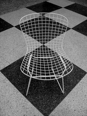Retro chair against black and white checkered floor pattern
