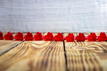 Row of red hearts on wooden background..