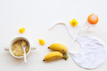 mashed banana healthy foods ,water bottle ,tier ,banana fruits breakfast of baby arrangement flat lay style on background white