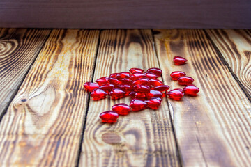 Hearts scattered randomly on wooden background..