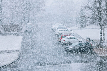 Snowfall in the city. Defocused heavy snowfall, car parking in background. Heavy snow concept