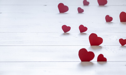 Red hearts on white wooden background