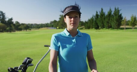 Portrait of female caucasian golf player crossing her arms while standing at golf course