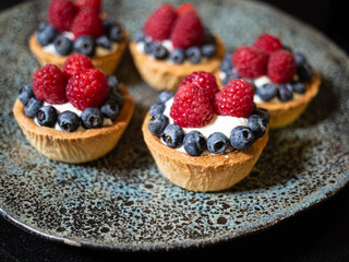 Basket with cream, blueberries and raspberries