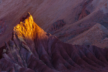 Sunset over bare eroded rocks in the volcanic Rainbow Valley (Valle de Arcoris) in the Atacama desert, Chile