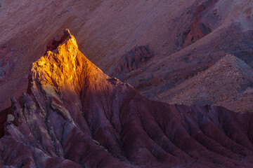 Sunset over bare eroded rocks in the volcanic Rainbow Valley (Valle de Arcoris) in the Atacama...