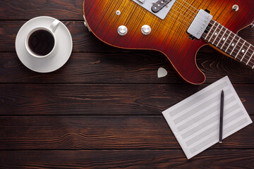 Beautiful electric guitar on with headphones and coffee desktop