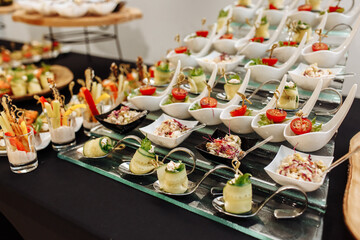 Festive Buffet. An assortment of cold cuts and canapes on wooden skewers. Cocktail reception at the party. catering with meats, fruits, cheeses and sandwiches. - obrazy, fototapety, plakaty