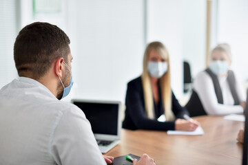 CEO wearing a face mask at a business meeting with employees