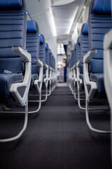 Empty dark blue passenger airplane seats in the cabin.
