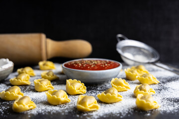 Homemade fresh tortellini on a kitchen table.