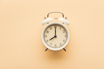White alarm clock on a yellow background top view