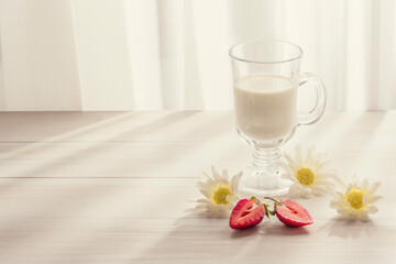to cut strawberries, daisies in the early morning on a white wooden surface