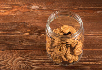 glass jar with biscuits on a wooden surface