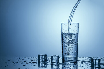 Pure drinking water is poured into a clear glass.