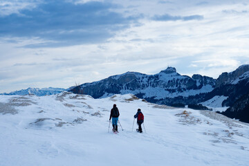 Fototapeta na wymiar Two snow shoe hikers along the ridge of Kronberg, a mountain in Sitzerland