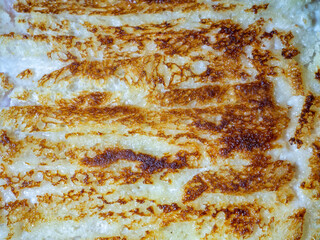 The narrow, porous toasted bread strips on the surface of the schnitzel fill the entire background....