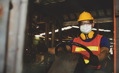 Concept factory health care : Male workers wearing face masks work to drive forklifts in industrial plants to ensure safety during the COVID-19 epidemic and toxic environmental pollution.