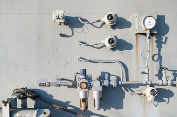 Pipes, valves and gauges system on stained wall of navy ship or battleship. Maritime transport concept