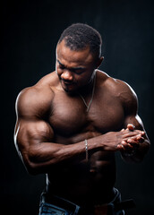 Fototapeta na wymiar Portrait of a bodybuilder african american in studio. Naked torso of an athlete. Strong muscules.
