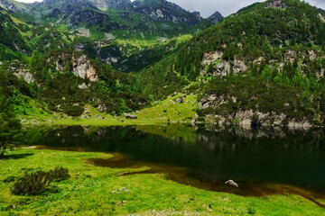 clear dark mountain lake in a green valley