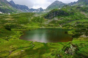 Naklejka na ściany i meble green valley with a mountain lake in the summer