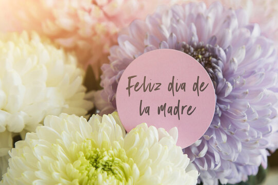 beautiful delicate bouquet of multicolored chrysanthemums with a white card with the inscription happy mother s day on spanish