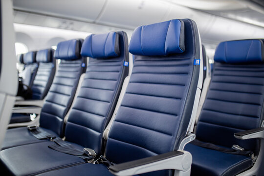 Dark blue passenger airplane seats in the cabin.