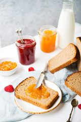 Fresh homemade bread with jam and milk, homemade simple food, light background