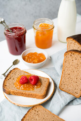Fresh homemade bread with jam and milk, homemade simple food, light background