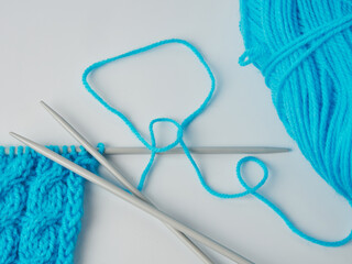 Needlework crochet, top view of yarn balls, flat spoon on light wood close-up