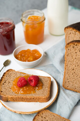 Naklejka na ściany i meble Fresh homemade bread with jam and milk, homemade simple food, light background
