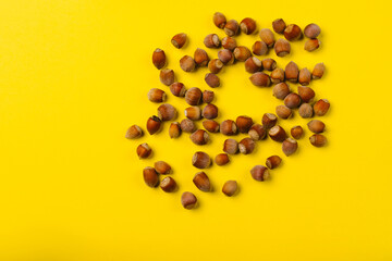 Hazelnuts on a illuminating background are scattered in the shape of a heart. St Valentines Day concept. Empty space.