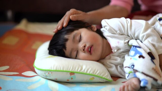 Mother seduces the child to sleep on the bed