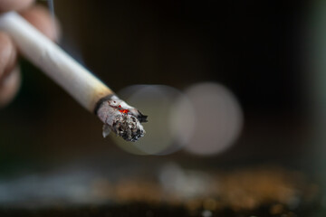 close up person holding a cigarette