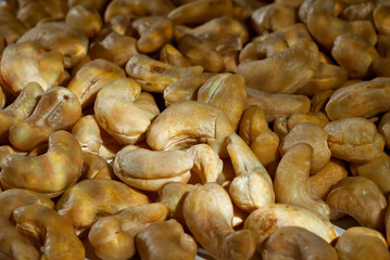 Cashew close up. Texture of nuts. Lots of nuts in a pile. Contrasting dramatic light as an artistic effect.