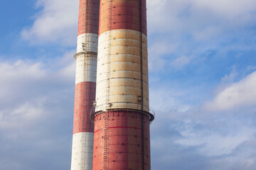 Close-up of old brick industrial chimneys by coal mine in Katowice. Abstract industrial background. Global warming, CO2 emission, coal energy issues, air pollution, climate change. 